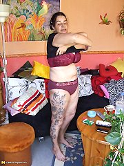 Tatooed mature slut showing her pussy